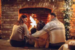 How to Keep your fireplace clean and safe this winter happy family around the fireplace Heat & Sweep Canton blog